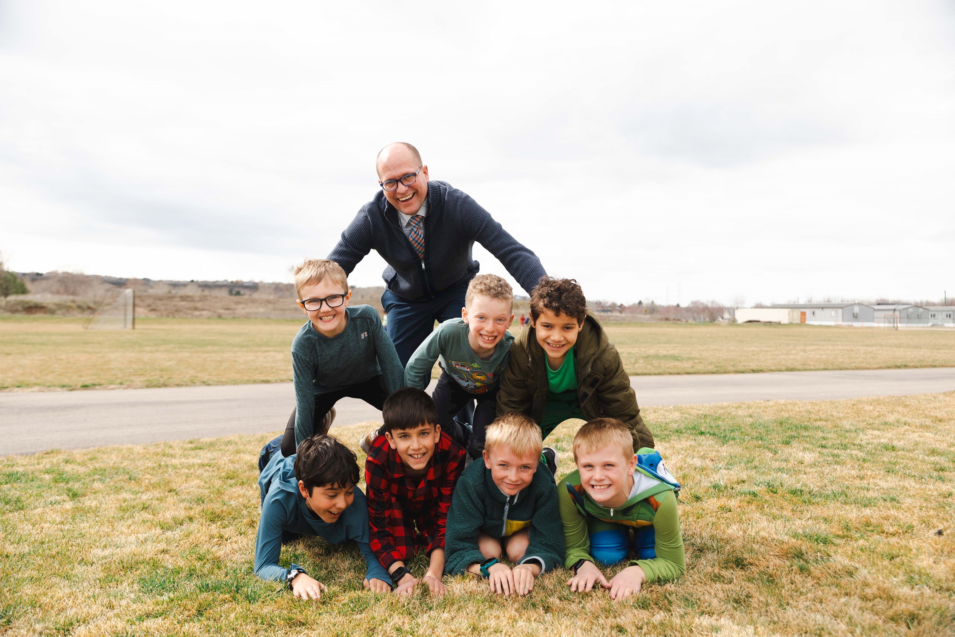 Mr. McKinnon helps Grade 2 & 4 boys form a pyramid